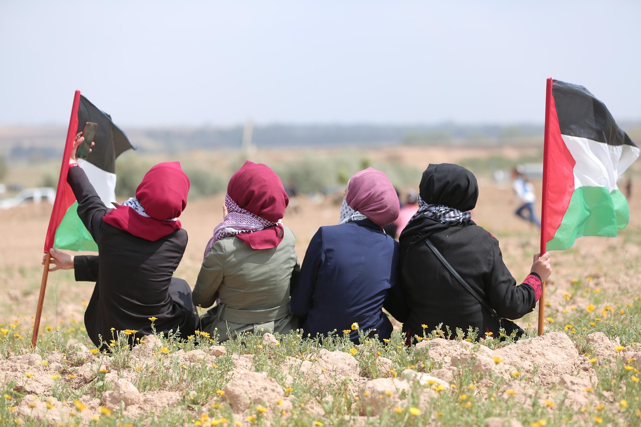back of children sitting in field