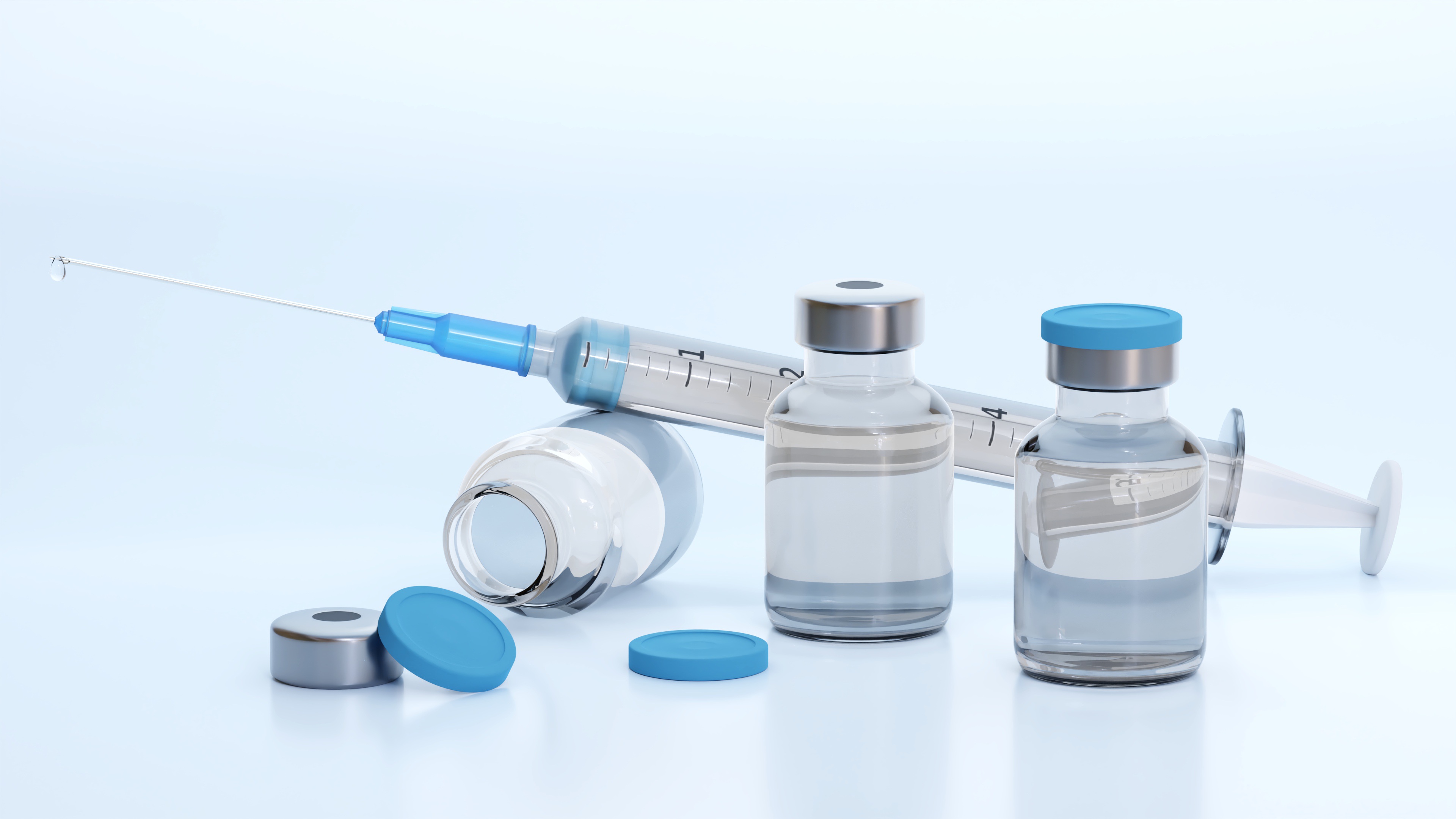 vials filled with liquid and a syringe on a white background